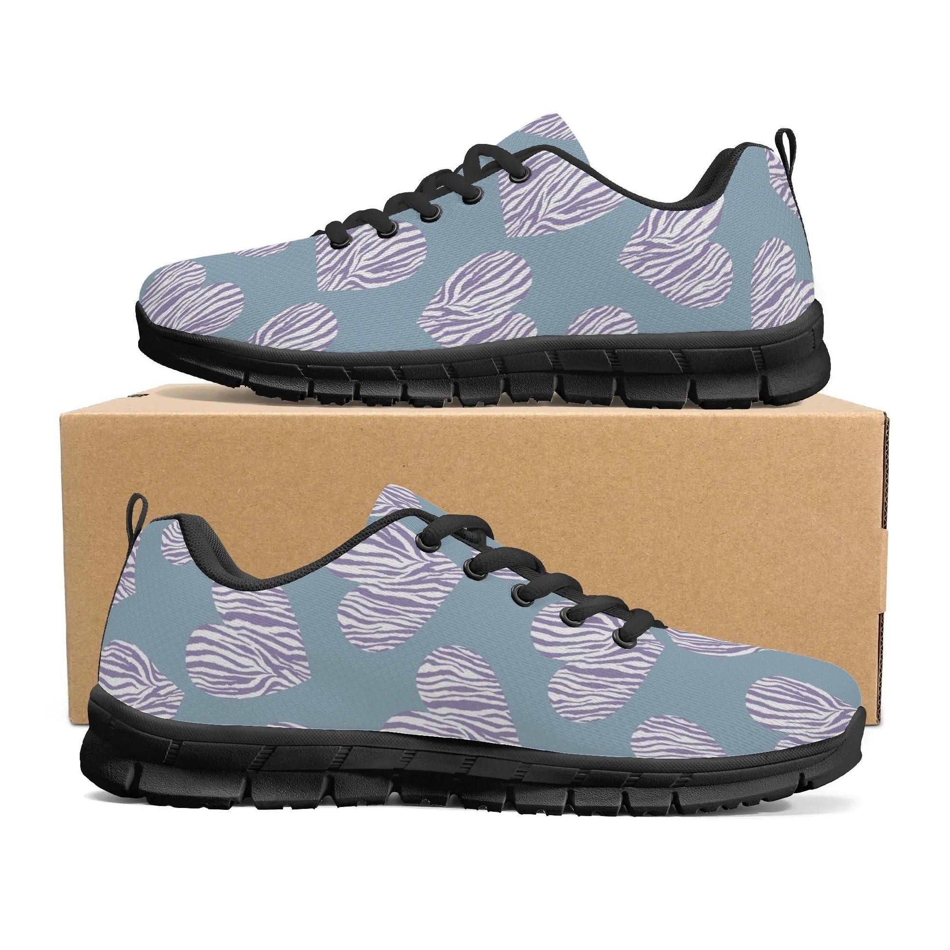 A pair of teal athletic shoes, named Comfort Meets Care: Stylish Nurses Heart Sneakers for Everyday Support, with black soles and laces, displayed resting on top of a brown shoebox. These cushioned shoes feature a pattern with white hearts and gray zebra stripes, making them both stylish and comfortable.