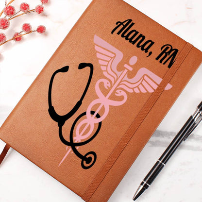 A Custom Medical Journal: Personalized Notebook for Doctors & Nurses - Leather made with vegan leather features a medical symbol and stethoscope illustration on the cover, with "Alana, RN" printed at the top. A silver pen rests beside the journal, complemented by red berries in the top left corner. This unique gift is both stylish and thoughtful.