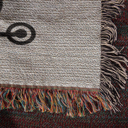 Close-up of a Personalized Nurse Heirloom Woven Blanket - Custom Keepsake for Healthcare Heroes with fringed edges. The blanket features a mix of earth tones, including beige and brown, and colorful fringes in red, yellow, blue, green, and orange at the edges. A black spiral pattern is visible on the beige section.