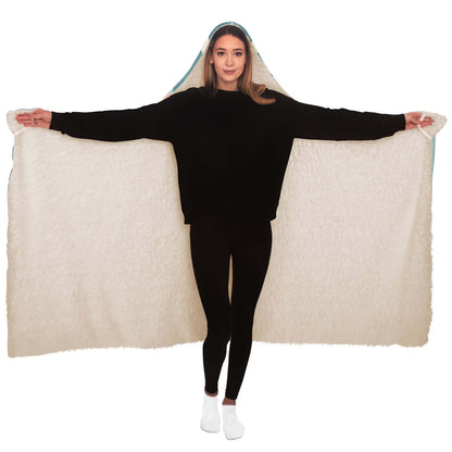 A person in black clothing stands with arms outstretched, displaying a large beige hooded blanket. With its soft, plush texture, this Personalized Nurses Hooded Blanket makes an ideal nurse gift for comfort and relaxation. The person wears white socks, standing against a plain white background.