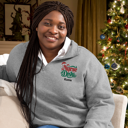 A cheerful nurse dons a grey Christmas fleece pullover while sitting comfortably on a couch in front of a christmas tree.